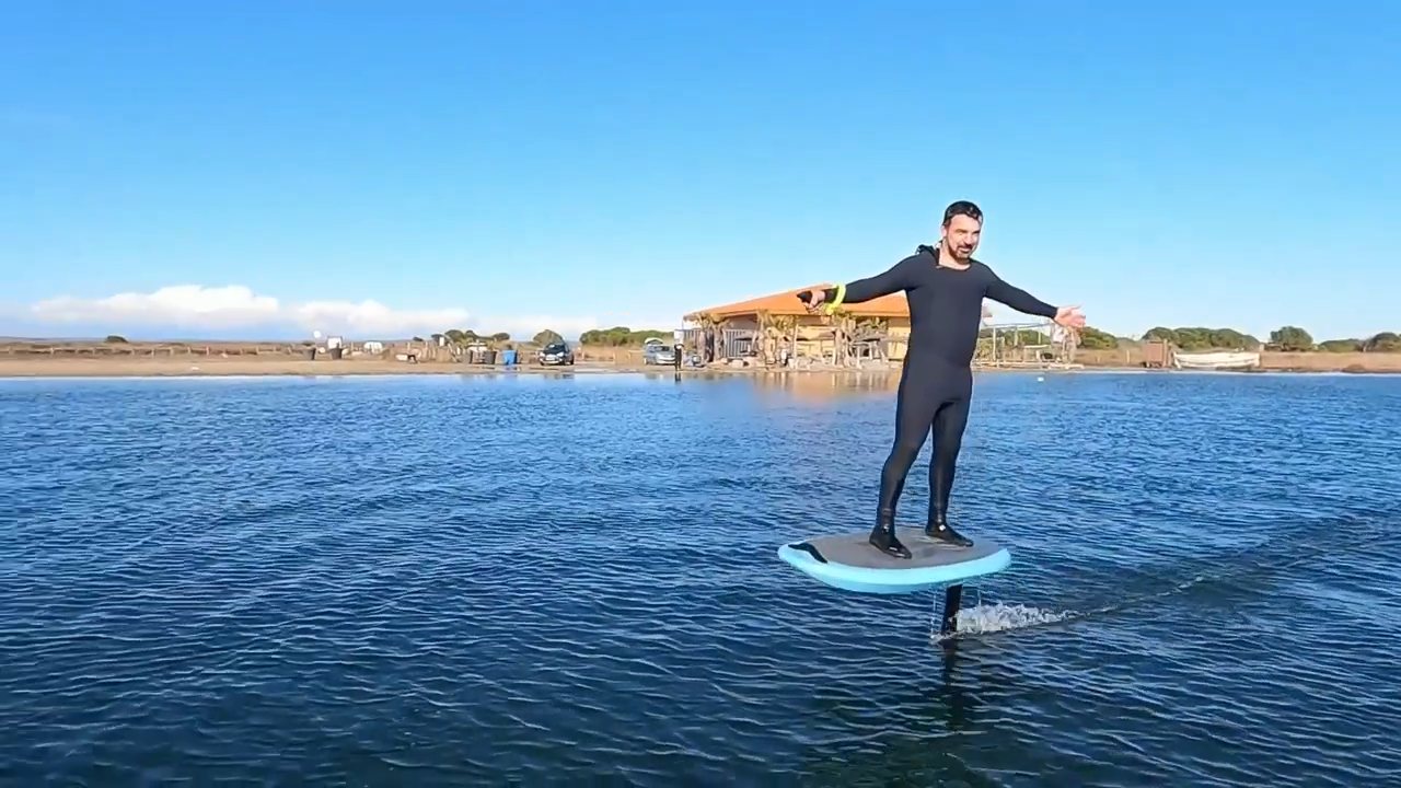 Rider debout sur un Lite Foil près de la plage